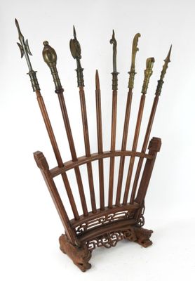 une chaise en bois sur laquelle sont posées plusieurs lances
