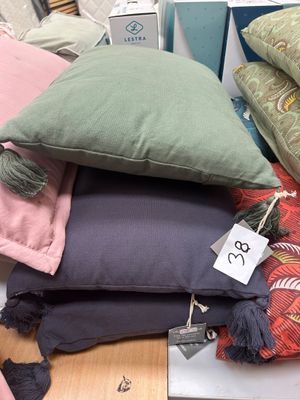 a pile of pillows on a table with a price tag on it