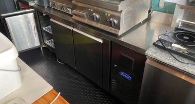 stainless steel counter top in a commercial kitchen with a stove and refrigerator