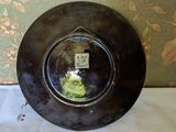 a black plate with a picture on it sitting on a table