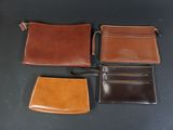 three different types of leather wallets on a black surface