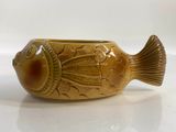a brown fish shaped bowl on a white surface