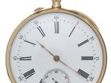 a gold pocket watch with roman numerals on the face