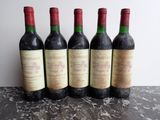 four bottles of wine are lined up on a table