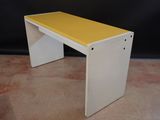 a white and yellow bench sitting on top of a carpeted floor