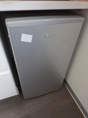 un petit réfrigérateur dans un coin de la cuisine
