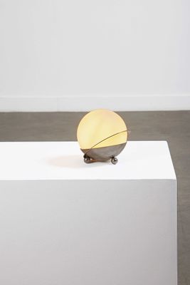 une image représentant une sculpture posée sur un socle blanc dans une pièce