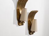 une paire d'appliques en laiton avec des lampes à abat-jour, fixées sur un mur blanc