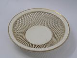 a white bowl with a gold rim on a white table