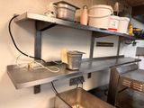 a metal shelf with pots and pans on it