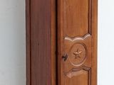 a tall wooden grandfather clock on display against a white wall