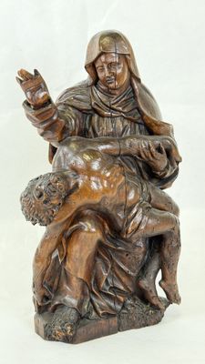 statue of a woman holding a child on her lap with a dog