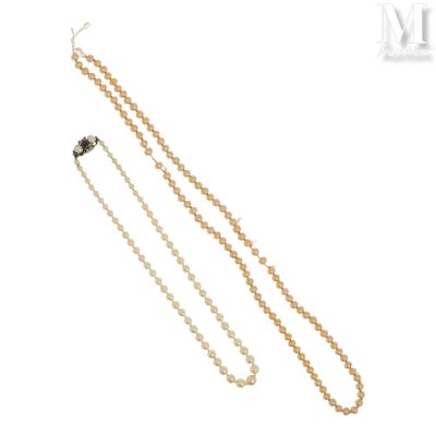 un gros plan sur une paire de colliers de perles sur fond blanc