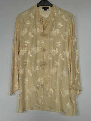 an image of a beige shirt with white flowers on it