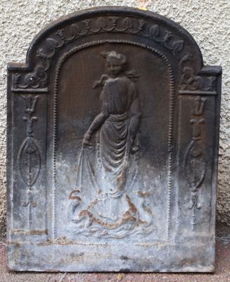 a statue of a woman holding a dog on a stone wall