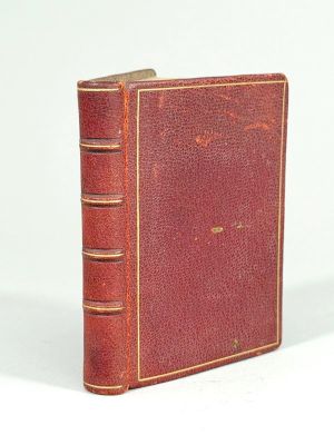 un vieux livre posé sur une table blanche à côté d'un mur blanc