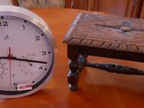 une horloge posée à côté d'un petit tabouret sur une table