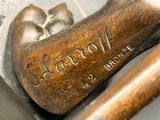 a bronze statue of a baseball bat and a ball on a table