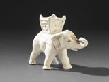 un petit éléphant blanc avec un bouclier sur le dos