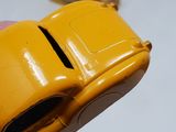 a person holding a yellow toy car in their hand