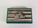 a box of green house toothbrushes on a white surface