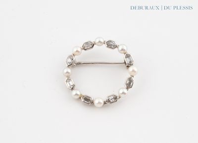 a close up of a ring with pearls on a white surface