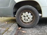 a white truck with a flat tire parked on the side of the road