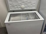 a white chest freezer sitting next to a blue refrigerator