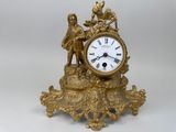 une horloge en or surmontée d'une statue
