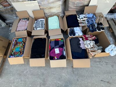 many boxes of clothing that are sitting on the ground