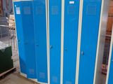 several blue lockers are lined up in a large warehouse