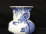a blue and white vase sitting on a black surface