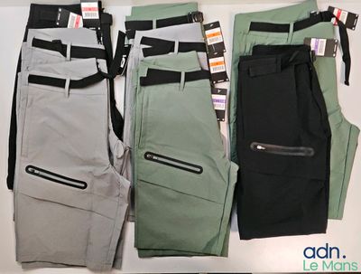 three pairs of men ' s pants are lined up on a table