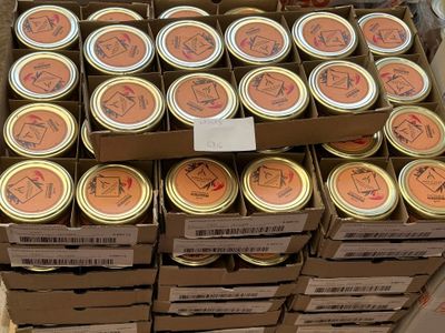 Dans un magasin, des cartons de conserves sont empilés les uns sur les autres