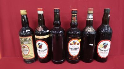 six bouteilles de vin sont alignées sur une surface rouge