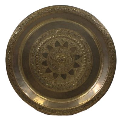 une image représentant une plaque en laiton ornée d'un motif circulaire