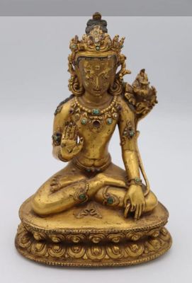 a gold statue of a person sitting on top of a table