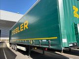 a green semi trailer parked in a parking lot