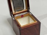 an open wooden box with a metal grater inside of it