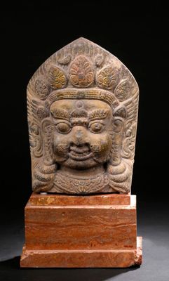 an image of a stone head on a wooden stand