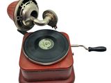 an old record player on a red wooden stand