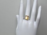 une photo d'une bague en or à la main d'un mannequin