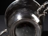 a silver cup with a chain around it on a table