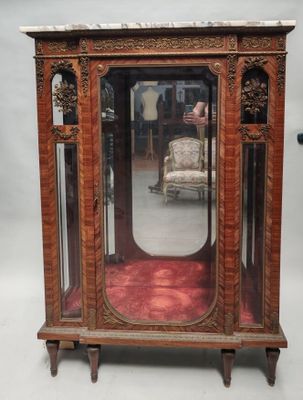un miroir posé sur un pied, avec une chaise devant