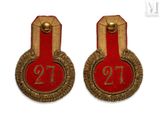 pair of red and gold badges with the number twenty on them