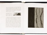 an open book with a black and white photo of a tree