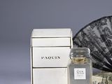 a bottle of perfume next to a fan and a box