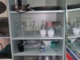 a green cabinet with many dishes and bowls on it