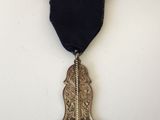 un gros plan d'une médaille ornée d'un ruban