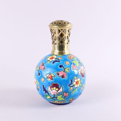 un petit vase bleu orné de fleurs, posé sur une surface blanche